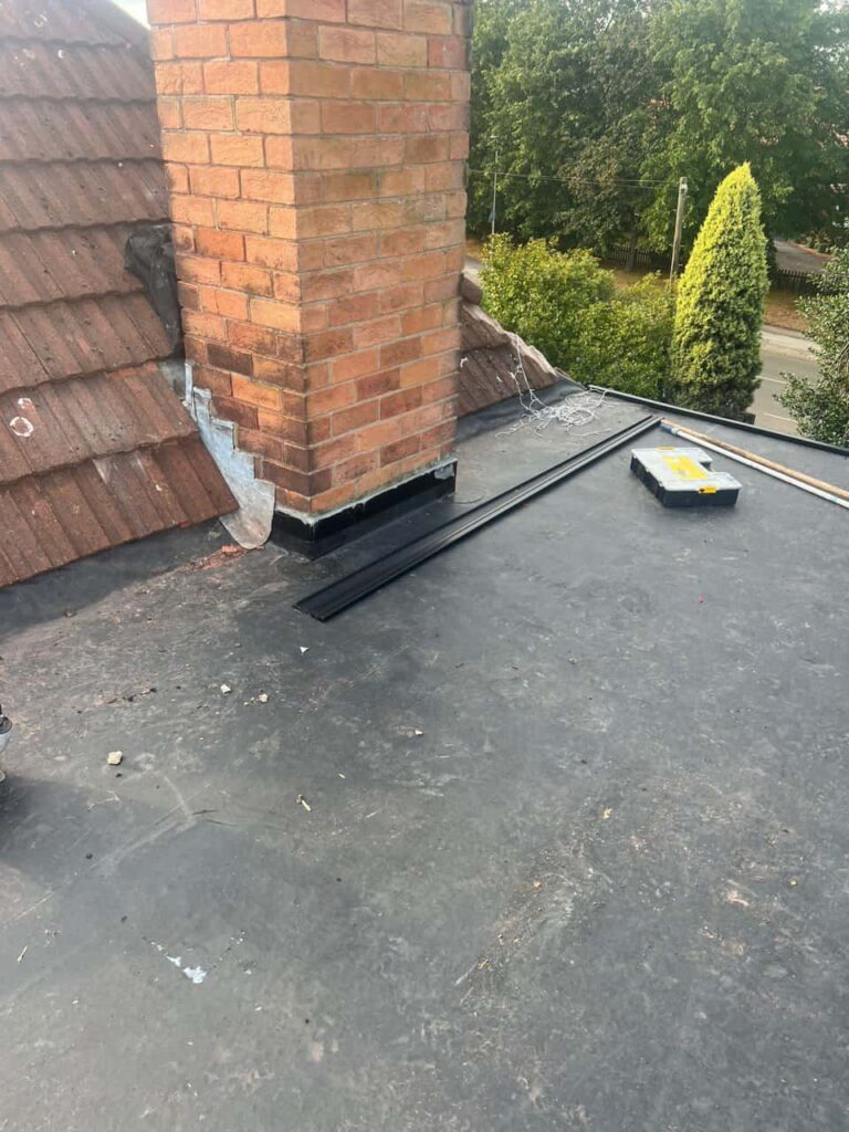 This is a photo of a flat roof which has just been repaired, there is also a chimney stack and some leadwork has also been dressed. Works carried out by Oadby Roofing Repairs